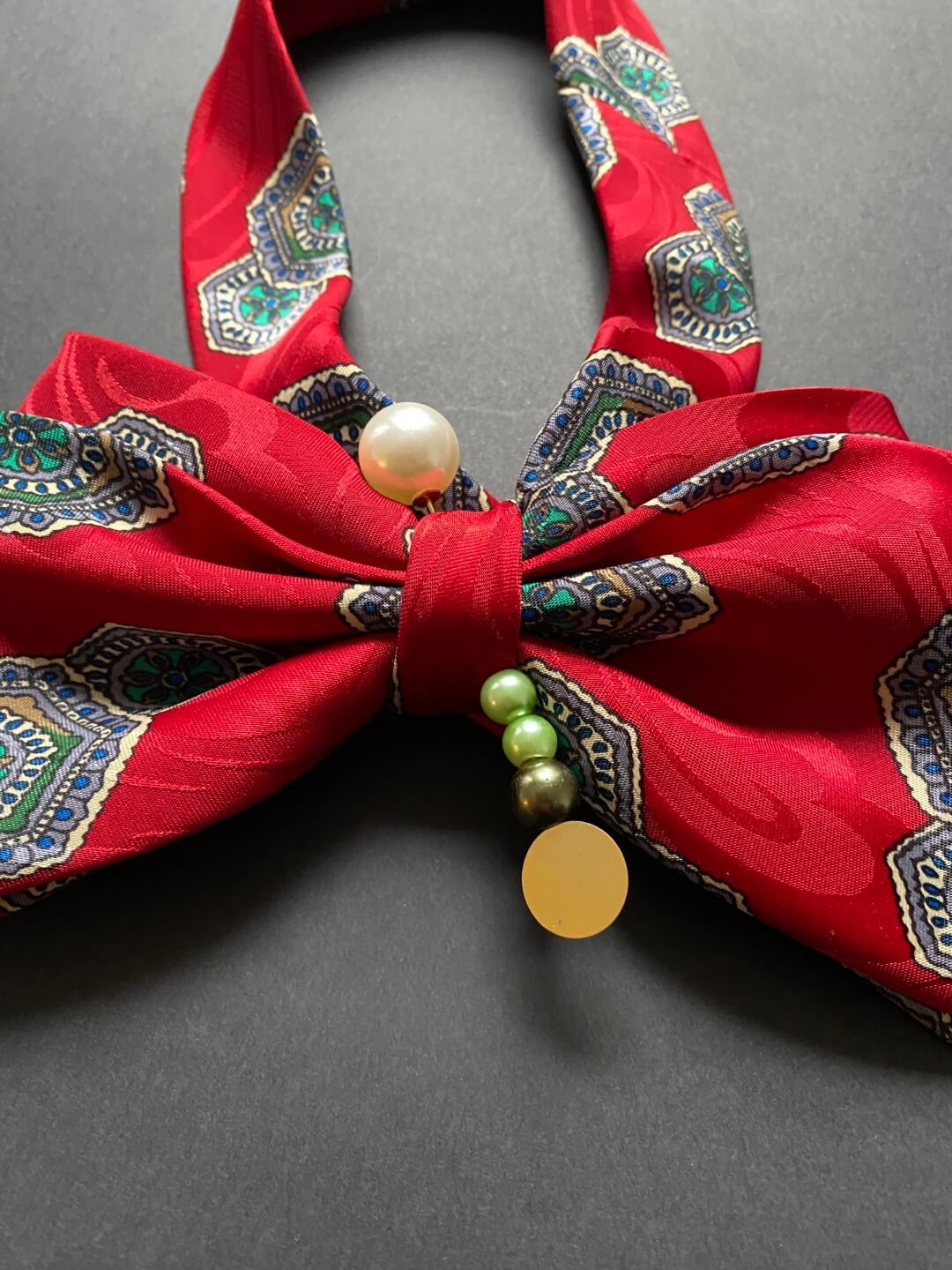Crvena unikatna mašna-kravata ukrašena ukrasnom iglom s biserima