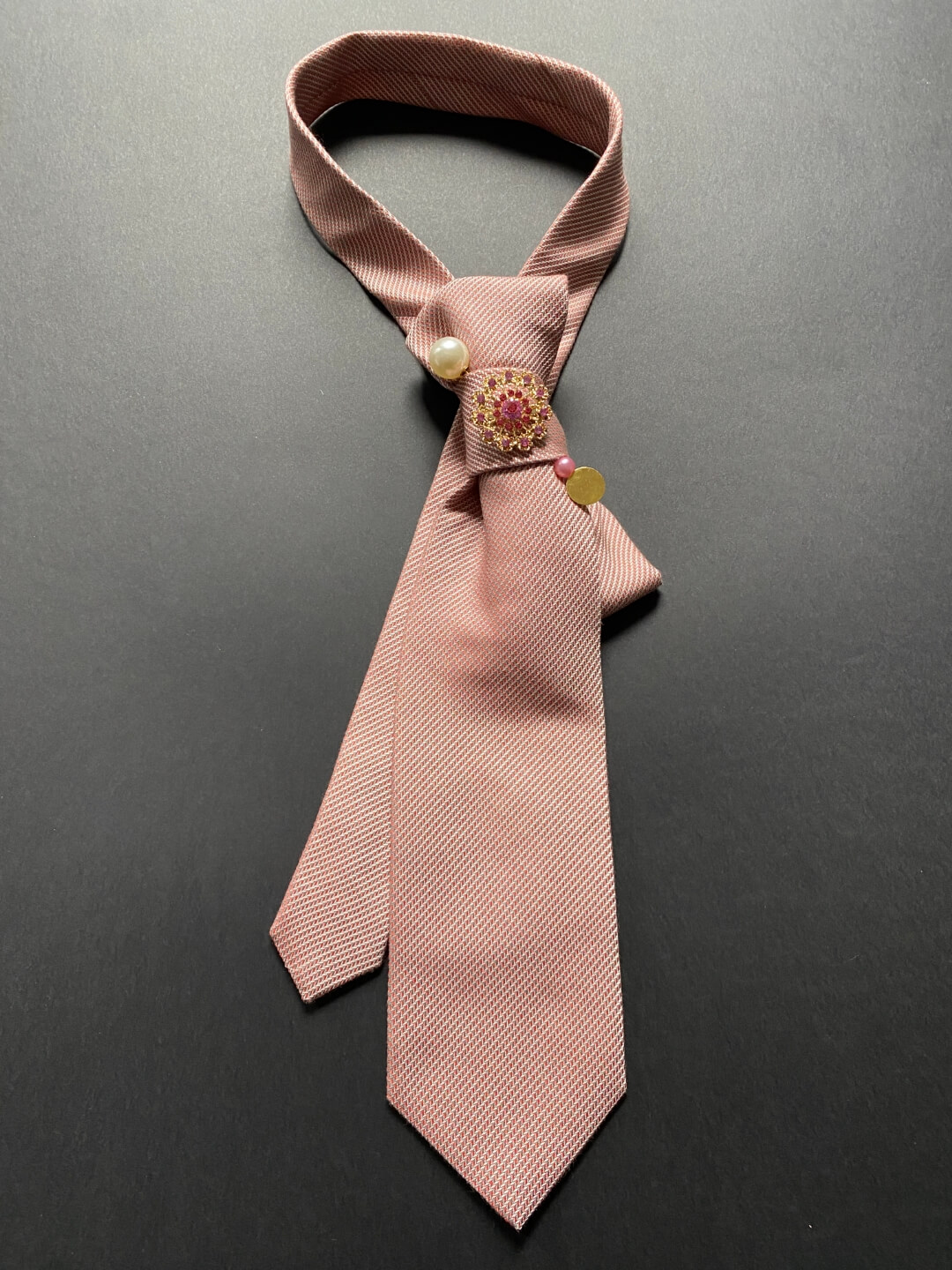 Svilena unikatna ženska kravata u puder-roza nijansi ukrašena brošem i iglom