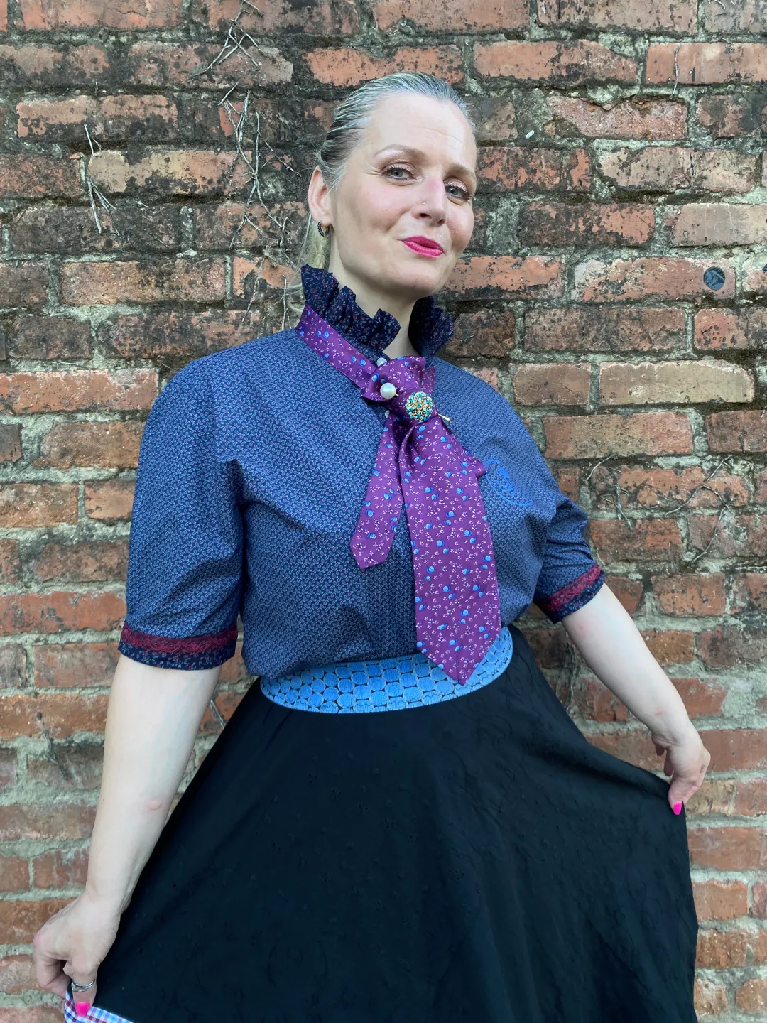 Svilena ljubičasta kravata s pužićima u kombinaciji s tamno plavom košuljom