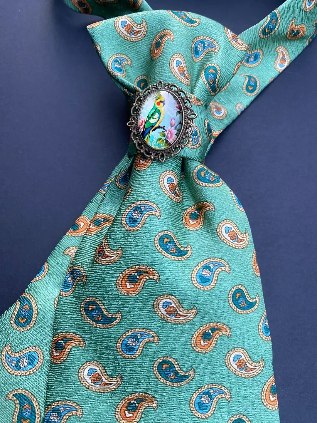 Svilena zelena kravata s paisley uzorkom i brošem u vintage stilu